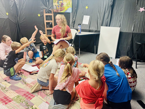 storytime in a setting with black, star-covered walls